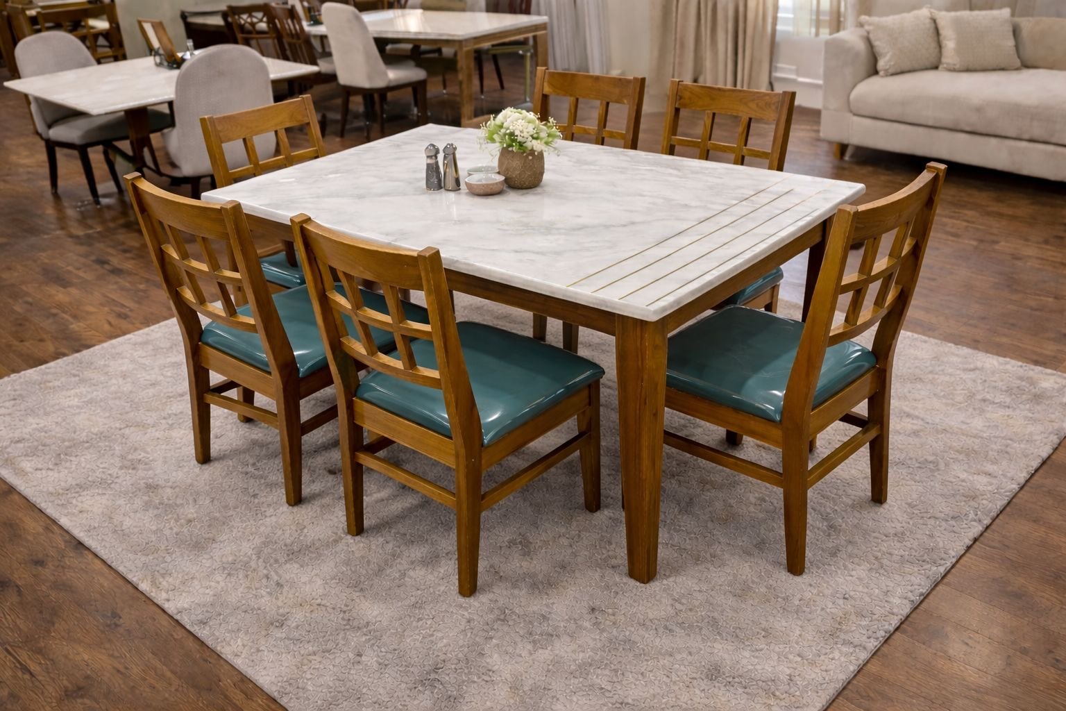 6-seater dining table with wooden chairs that have teal vinyl seat cushions and a white marble top.